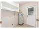 Laundry room with utility sink and shelves above the water heater at 17247 N 106Th Ave, Sun City, AZ 85373