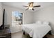 Well lit bedroom featuring hard wood floors, a ceiling fan, and view to the neighborhood at 18 N 132Nd St, Chandler, AZ 85225