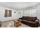 Cozy living room with a brown sofa, window, and tile flooring at 1813 W Tamarisk St, Phoenix, AZ 85041