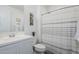 Bright bathroom features a white vanity, mirror, and shower with striped curtain at 1915 W Hide Trl, Phoenix, AZ 85085