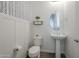 Charming powder room featuring stylish wallpaper, wainscoting, and pedestal sink creating a welcoming space at 1915 W Hide Trl, Phoenix, AZ 85085