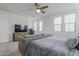 This bedroom features a ceiling fan, TV, desk, and several windows for natural light at 1915 W Hide Trl, Phoenix, AZ 85085