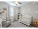 Cozy Bedroom featuring a white crib, chair, and cheerful daisy-themed decor at 1915 W Hide Trl, Phoenix, AZ 85085