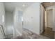 Bright hallway with carpeted floor and neutral walls, featuring a staircase and doorways to other rooms at 1915 W Hide Trl, Phoenix, AZ 85085