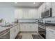 This kitchen features stainless appliances, granite counters, and white cabinets for a clean and modern aesthetic at 1915 W Hide Trl, Phoenix, AZ 85085