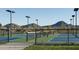 Scenic tennis courts featuring mountain views, with blue and green playing surfaces and modern lighting fixtures at 1915 W Hide Trl, Phoenix, AZ 85085