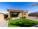 Landscaped backyard featuring a green lawn, gravel accents, and a covered patio at 2019 E Entoro Dr, Casa Grande, AZ 85122