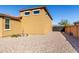 Gravel side yard and stucco house, creating a low-maintenance and aesthetically pleasing design at 2019 E Entoro Dr, Casa Grande, AZ 85122