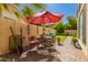 Cozy backyard patio with wrought iron furniture, a red umbrella, and paver flooring at 21 W Ranch Rd, Tempe, AZ 85284