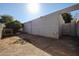 Spacious backyard area with dirt and shrubbery enclosed by a stucco wall, ideal for outdoor activities at 2113 N Squire Ave, Tempe, AZ 85288