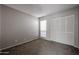 Simple bedroom featuring neutral walls, plush carpeting, a large window, and a closet at 2113 N Squire Ave, Tempe, AZ 85288