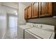 Practical laundry room with a washer, dryer, and cabinet storage at 2113 N Squire Ave, Tempe, AZ 85288