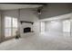 Bright living room with high ceilings, brick fireplace, ceiling fan, and large windows with wooden shutters at 2113 N Squire Ave, Tempe, AZ 85288