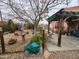 Landscaped backyard featuring mature trees, rock features and a covered patio at 21817 W Harding Ave, Wittmann, AZ 85361