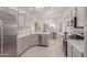 Well-lit kitchen with stainless steel appliances, white cabinets, and a view of the dining area at 22120 N Old Mine Rd, Sun City West, AZ 85375