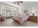 This main bedroom features tiled floors, a ceiling fan, and large windows for plenty of natural light at 22120 N Old Mine Rd, Sun City West, AZ 85375