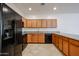 Well-lit kitchen featuring wood cabinets and black appliances at 2260 S Deerfield Ln, Gilbert, AZ 85295