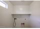 Bright laundry room featuring a built-in shelf for convenient storage and organization at 2260 S Deerfield Ln, Gilbert, AZ 85295