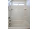 Bright tub-shower combination with white tiled walls and built-in shelving at 2260 S Deerfield Ln, Gilbert, AZ 85295