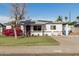 Inviting single-story home with solar panels, vibrant landscaping, and a cozy seating area at 2302 E Sells Dr, Phoenix, AZ 85016