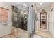 This bathroom features a tiled walk-in shower with glass door, window, and a neutral color palette at 2302 E Sells Dr, Phoenix, AZ 85016