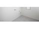 A well-lit laundry room space with a window and white tile flooring at 24175 W Hidalgo Ave, Buckeye, AZ 85326