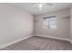 This comfortable bedroom features neutral walls, plush carpeting, a ceiling fan, and a view from the window at 2643 E Jerome Ave, Mesa, AZ 85204