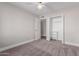 A light-filled bedroom features neutral walls, plush carpeting, a ceiling fan, and an open closet space at 2643 E Jerome Ave, Mesa, AZ 85204