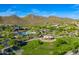 Aerial view of a community featuring a splash pad, playground, lush green spaces, and desert mountain views at 28735 N 21St Ave, Phoenix, AZ 85085