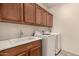 Well-lit laundry room with white washer and dryer, overhead cabinets, and convenient sink at 28735 N 21St Ave, Phoenix, AZ 85085