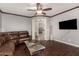 Comfortable living room with wood floors, leather sofa, ceiling fan, and an open floorplan to the kitchen at 28735 N 21St Ave, Phoenix, AZ 85085