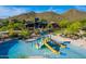 Community pool area featuring a splash pad, water slide and lounge seating with desert mountain views at 28735 N 21St Ave, Phoenix, AZ 85085