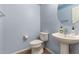 Charming powder room featuring a pedestal sink, toilet, and light blue walls at 28735 N 21St Ave, Phoenix, AZ 85085