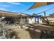 Landscaped backyard with awning-covered patio, walkway, and vibrant flowers at 3133 W Christy Dr, Phoenix, AZ 85029