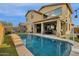 Wonderful view of the private backyard pool surrounded by lush greenery and a covered patio at 3238 W White Canyon Rd, San Tan Valley, AZ 85144