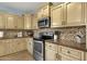 Well-lit kitchen with stainless steel appliances, tile backsplash, and plenty of cabinet space at 3238 W White Canyon Rd, San Tan Valley, AZ 85144