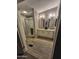 Well-lit bathroom with double vanity, shower with glass door, and stylish gray-toned flooring at 329 N 83Rd Pl, Mesa, AZ 85207