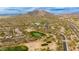 Expansive aerial view featuring desert homes near a golf course, set against a mountain backdrop and desert landscape at 33389 N 71St St, Scottsdale, AZ 85262