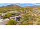 Panoramic aerial shot showcasing a desert home with solar panels, a mountain backdrop, and desert landscape at 33389 N 71St St, Scottsdale, AZ 85262