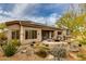 Expansive backyard featuring desert landscaping, a soothing pond, a classic fountain, and a covered patio for entertaining at 33389 N 71St St, Scottsdale, AZ 85262