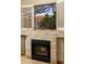 Close up of fireplace with white brick mantle, wood burning fire and view of the backyard at 33389 N 71St St, Scottsdale, AZ 85262