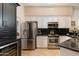 Modern kitchen with stainless steel appliances, wine cooler, and dark granite countertops at 33389 N 71St St, Scottsdale, AZ 85262