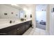 Bathroom featuring a double vanity and white tile floors that lead into an open bedroom at 3482 N 300Th Dr, Buckeye, AZ 85396