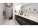 Bathroom with double vanity, black cabinets, a large mirror, and decorative tile flooring at 3482 N 300Th Dr, Buckeye, AZ 85396