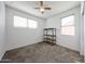 Bedroom with a ceiling fan, carpet, and a shelf near the window and blinds at 3482 N 300Th Dr, Buckeye, AZ 85396