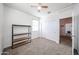 Bedroom with a ceiling fan, closet, and a shelf, with an open doorway to another room at 3482 N 300Th Dr, Buckeye, AZ 85396