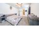 Well-lit bedroom with plush carpeting, ceiling fan, and a view of the en suite bathroom at 3482 N 300Th Dr, Buckeye, AZ 85396