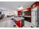 Modern kitchen with a granite island, stainless steel appliances, black cabinets, and tiled floors at 3482 N 300Th Dr, Buckeye, AZ 85396