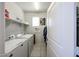 Well-lit laundry room featuring white washer and dryer, shelving, and tile flooring at 3482 N 300Th Dr, Buckeye, AZ 85396