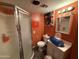 Orange bathroom featuring a shower, toilet, sink and gray vinyl plank flooring at 3527 W Almeria Rd, Phoenix, AZ 85009